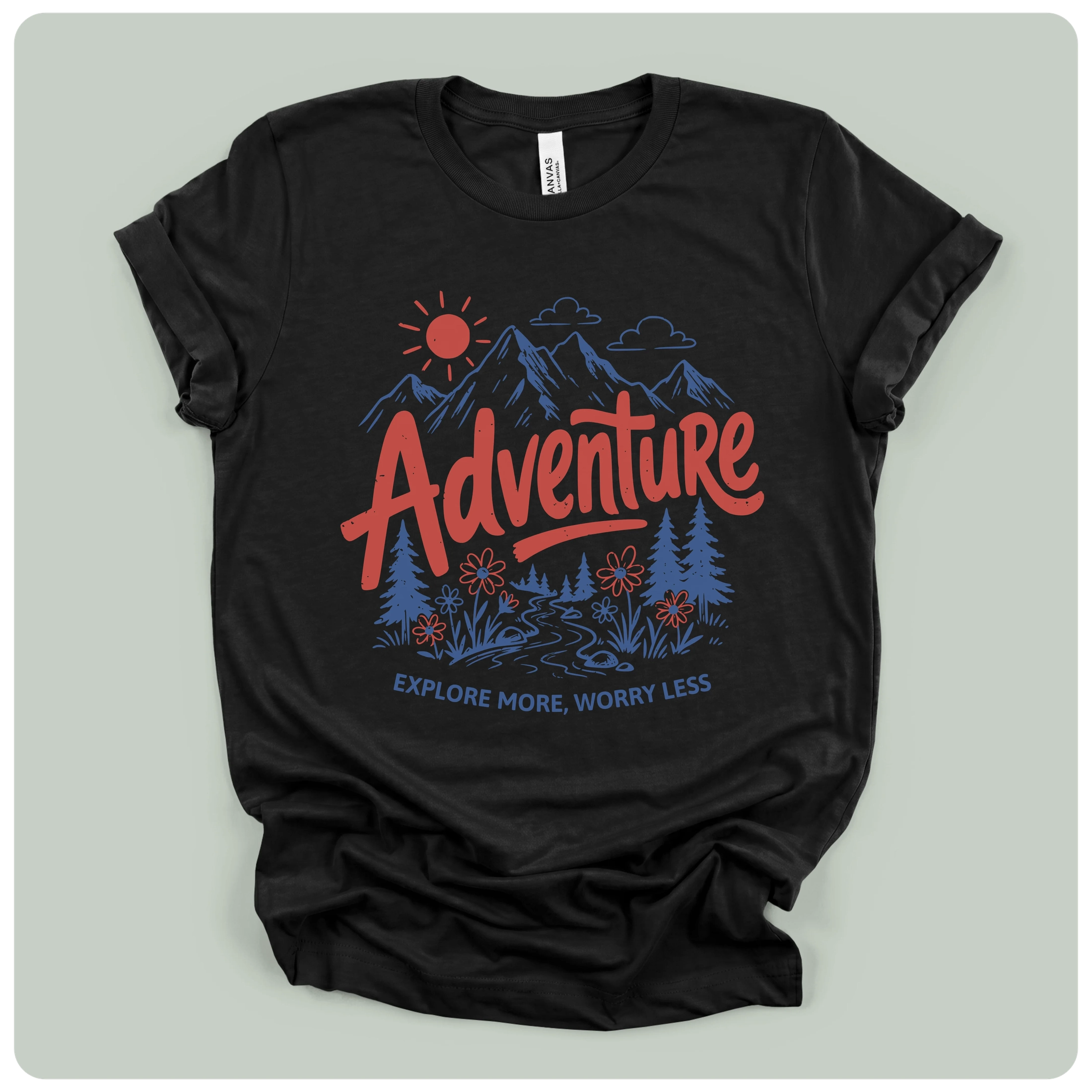 A black short-sleeve graphic t-shirt laid flat on a light gray background. The shirt features a colorful graphic print with a red 'Adventure' text, blue mountains, trees, and a sun, with the phrase 'EXPLORE MORE, WORRY LESS' printed below.