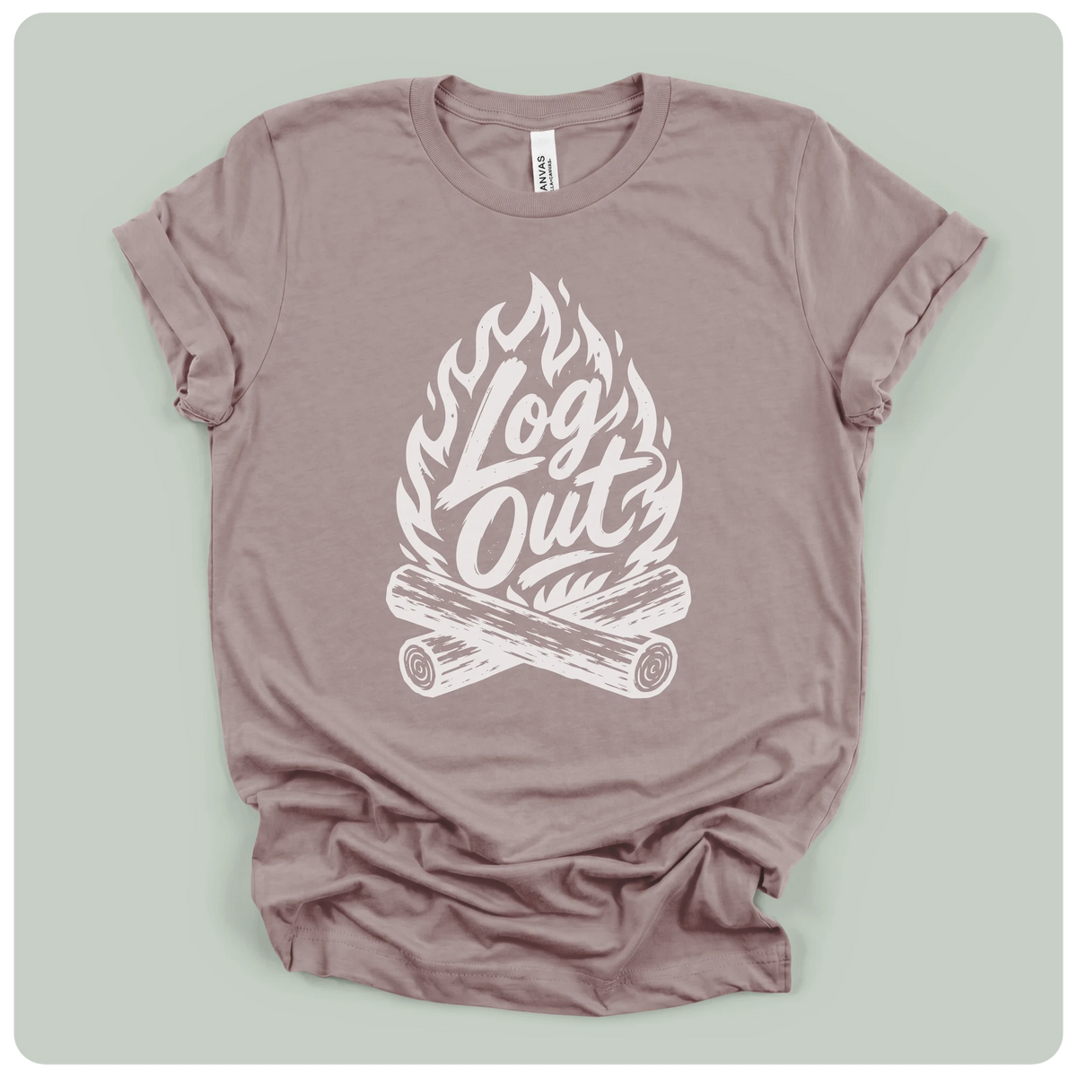 A dusty mauve crewneck t-shirt with a white graphic print of a campfire and the words 'Log Out' in script, laid flat on a light sage green background.