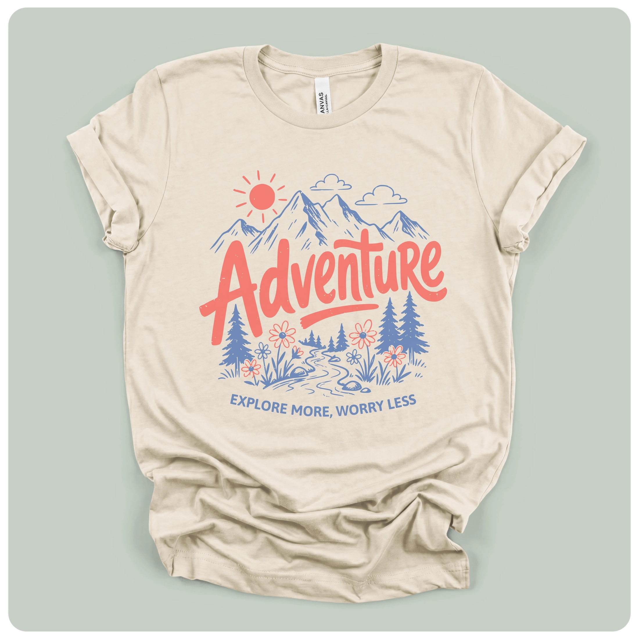 A beige short-sleeve t-shirt with a colorful graphic print on the front. The graphic features a red sun, blue mountains, pine trees, and the word 'Adventure' in red script, with the phrase 'EXPLORE MORE, WORRY LESS' printed below in blue.