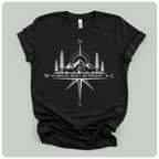 A black short-sleeve crewneck t-shirt with a white graphic print of a compass rose, mountains, pine trees, and a sun, with the text 'W UNPLUG. RESET.